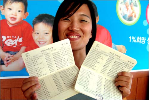 생명나눔재단 관계자가 민재군 돕기 성금 통장을 보며 환하게 웃고 있다. 